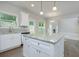 Spacious kitchen with island, stainless steel appliances, gray backsplash, and natural light from large windows at 247 Lotus Ln, Covington, GA 30016