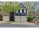 Inviting home exterior featuring a well-manicured lawn, covered entrance, and two-car garage with stylish, dark blue siding at 2700 Ridge Run Tr Trl, Duluth, GA 30097