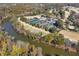 Aerial view of tennis courts and a pool next to a river, surrounded by lush trees and homes in a beautiful community at 300 Brayward Chase, Roswell, GA 30076