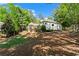 Spacious backyard with a lush lawn, surrounded by mature trees, showcasing a recreational trampoline and natural landscape at 300 Brayward Chase, Roswell, GA 30076