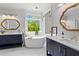 Bright bathroom with double vanity, free-standing tub, modern fixtures and a large window with shuttered blinds at 300 Brayward Chase, Roswell, GA 30076