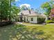 Charming stucco home featuring mature trees, manicured lawn, and covered entryway at 300 Brayward Chase, Roswell, GA 30076