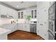 This kitchen features white cabinets, stainless steel appliances, and hardwood flooring at 300 Brayward Chase, Roswell, GA 30076