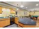 Features a kitchen area, sink, and island with chairs, adjacent to a billiards table and foosball table in the basement at 300 Brayward Chase, Roswell, GA 30076