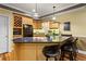Cozy kitchen features a wine rack, black appliances, granite countertop, and pendant lighting above the breakfast bar at 300 Brayward Chase, Roswell, GA 30076