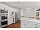 Bright kitchen featuring white cabinets, stainless steel appliances, an island and hardwood floors at 300 Brayward Chase, Roswell, GA 30076