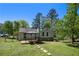 Large backyard featuring a deck with a pergola, lush greenery, and stepping stones at 6500 Chickasaw Dr, Douglasville, GA 30135