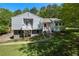 Charming two-story home featuring a covered balcony and a walkway surrounded by lush greenery at 6500 Chickasaw Dr, Douglasville, GA 30135