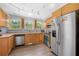 Bright kitchen offering stainless steel appliances and wooden cabinets, new flooring, and track lighting at 6500 Chickasaw Dr, Douglasville, GA 30135