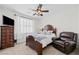 Cozy bedroom featuring a ceiling fan, wood furnishings, and comfortable seating area at 1228 W Oaks Way, Woodstock, GA 30188