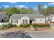 Charming single-story home featuring a well-manicured lawn and a classic design with black shutters at 1228 W Oaks Way, Woodstock, GA 30188