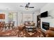 Cozy living room and dining area with a fireplace, ceiling fan and modern accents at 1228 W Oaks Way, Woodstock, GA 30188