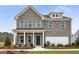 Charming two-story home featuring a gray brick facade, covered porch, and manicured landscaping at 6102 Marigold Way, Atlanta, GA 30349