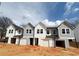 New construction townhomes showing white and gray siding, black roofs and front garages at 11598 E Lovejoy Rd, Hampton, GA 30228