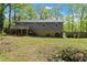 Back exterior of home with back deck shows second story and basement walk out, surrounded by mature trees at 230 Oakridge Se Dr, Cartersville, GA 30121