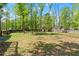 Expansive backyard surrounded by lush trees and a wooden fence at 230 Oakridge Se Dr, Cartersville, GA 30121