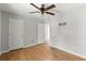 Bedroom with hardwood floors, two closets, a ceiling fan, and view of another room at 230 Oakridge Se Dr, Cartersville, GA 30121