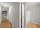 Hallway with hardwood floors and neutral walls, view of utility area and bathroom space at 230 Oakridge Se Dr, Cartersville, GA 30121