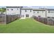 Spacious, grassy backyard, enclosed by a wooden fence, with view of townhome exteriors at 1439 Brookmere Way, Cumming, GA 30040