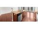 Modern kitchen island featuring a granite countertop, stainless steel dishwasher, and hardwood floors at 1439 Brookmere Way, Cumming, GA 30040