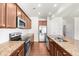 Modern kitchen features stainless steel appliances, granite countertops, tiled backsplash and sleek cabinets at 1439 Brookmere Way, Cumming, GA 30040
