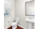 Powder room features a pedestal sink, wood-look flooring, and window at 1439 Brookmere Way, Cumming, GA 30040