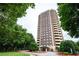 Exterior shot of a tall apartment building surrounded by lush green trees at 1501 Clairmont Rd # 1818, Decatur, GA 30033