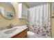 Bright bathroom featuring floral shower curtain, white fixtures, and vanity storage at 1760 Commonwealth Trl, Cumming, GA 30041