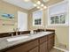 Bright bathroom featuring a double vanity with a granite countertop and a large mirror with vanity lighting at 1760 Commonwealth Trl, Cumming, GA 30041