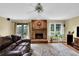 Bright living room featuring a brick fireplace, hardwood floors, and many windows at 1760 Commonwealth Trl, Cumming, GA 30041