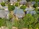 An aerial view showcasing a brick home with a deck and mature trees in a residential neighborhood at 1045 Westcroft Ln, Roswell, GA 30075