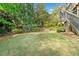 Flat backyard with mature trees and wooden fence at 1045 Westcroft Ln, Roswell, GA 30075