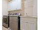 Bright laundry room featuring modern washer, dryer, cabinets, counter top, and utility sink at 1045 Westcroft Ln, Roswell, GA 30075
