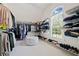 Spacious walk-in closet with custom shelving, storage, bright window, and a plush ottoman at 1045 Westcroft Ln, Roswell, GA 30075