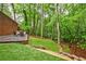 Landscaped backyard featuring lush lawn, mature trees, a patio, and a stone retaining wall at 1250 Northcliff Trce, Roswell, GA 30076