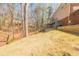 This backyard has a small retaining wall and is surrounded by trees at 1250 Northcliff Trce, Roswell, GA 30076