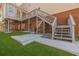 This backyard has artificial grass, a concrete patio, and stairs leading up to a deck at 1250 Northcliff Trce, Roswell, GA 30076