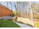 The backyard has a stone wall, natural trees, and a firepit area at 1250 Northcliff Trce, Roswell, GA 30076