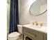 Bathroom featuring a modern vanity with sleek fixtures and a round decorative mirror at 1250 Northcliff Trce, Roswell, GA 30076
