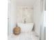 Bright bathroom features a soaking tub with marble accent wall and flooring plus stylish woven stool at 1250 Northcliff Trce, Roswell, GA 30076