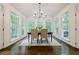 Sun-filled dining room with hardwood floors, modern chandelier, and large windows overlooking the backyard at 1250 Northcliff Trce, Roswell, GA 30076