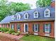 Beautiful brick home featuring dormer windows, a well-manicured lawn, and an inviting entryway at 1250 Northcliff Trce, Roswell, GA 30076