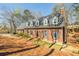 Charming brick home with a chimney, dormer windows, and dark shutters surrounded by tall trees at 1250 Northcliff Trce, Roswell, GA 30076