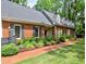 Charming brick home featuring a well-manicured lawn, beautiful landscaping and a red brick walkway at 1250 Northcliff Trce, Roswell, GA 30076