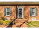 Inviting front entrance with a stylish black door, flanked by sconces and lush greenery at 1250 Northcliff Trce, Roswell, GA 30076