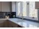 Kitchen sink with a brass faucet, dark backsplash, and window overlooking the backyard at 1250 Northcliff Trce, Roswell, GA 30076
