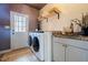 Laundry room featuring a white washer and dryer with granite countertops and wood cabinets at 1250 Northcliff Trce, Roswell, GA 30076