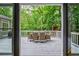 Outdoor deck with dining furniture overlooking a serene wooded backyard, accessible from the living room at 1250 Northcliff Trce, Roswell, GA 30076