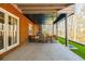 The covered patio has seating to enjoy the yard with artificial grass and mature trees at 1250 Northcliff Trce, Roswell, GA 30076