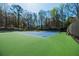 Well-maintained tennis court with green and blue surface surrounded by mature trees at 1250 Northcliff Trce, Roswell, GA 30076
